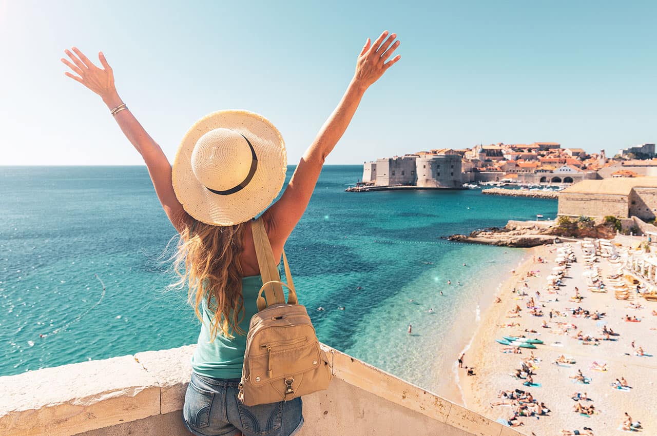 Happy woman tourist enjoying view of the old town of dubrovnik in croatia