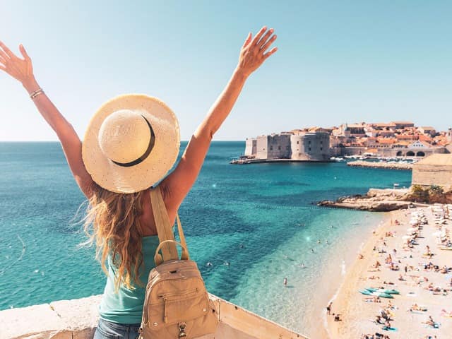 Happy woman tourist enjoying view of the old town of dubrovnik in croatia