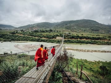 Monges atravessando ponte Butão