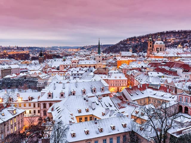 Prague in winter time view on snowy roofs with historical buildings