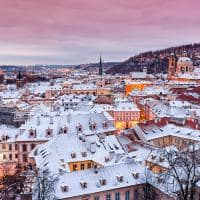 Prague in winter time view on snowy roofs with historical buildings