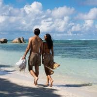 Raffles seychelles casal caminhando praia