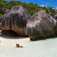 Raffles seychelles casal sentado mar pedras